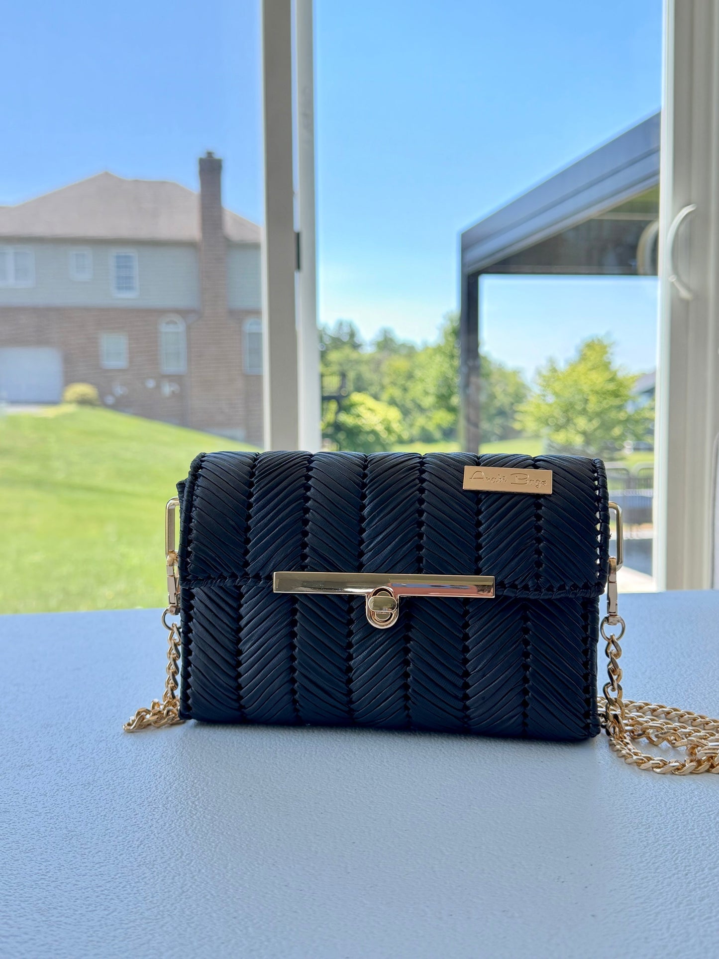 Black handwoven mini clutch with gold chain strap