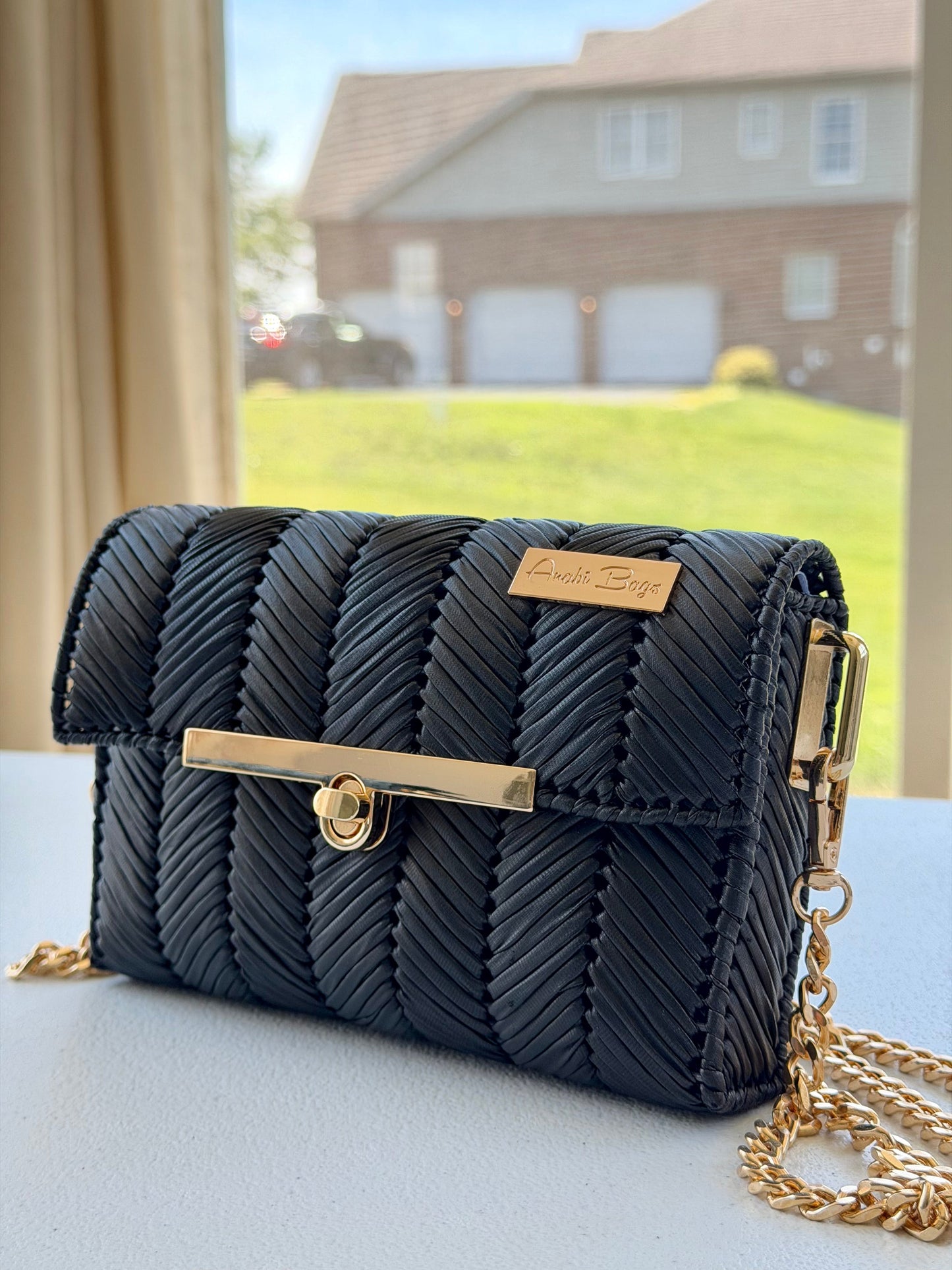 Black handwoven mini clutch with gold chain strap