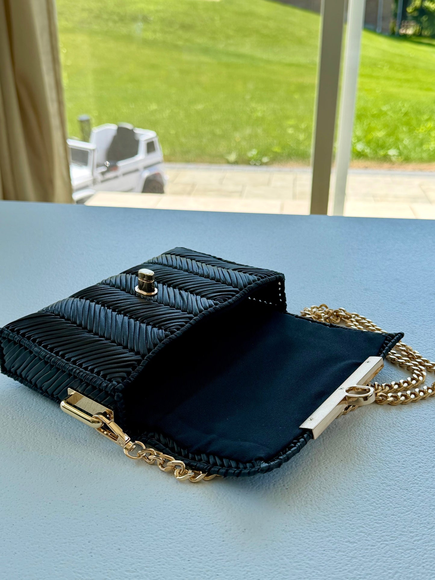 Black handwoven mini clutch with gold chain strap